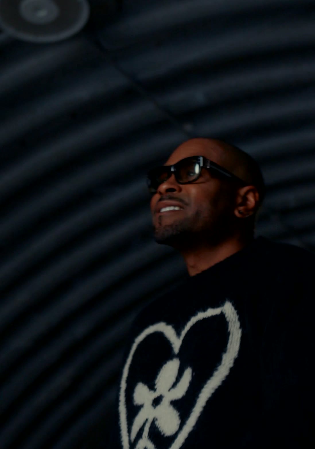 Aaron Skyy smiling and looking up under the tunnel's ribbed ceiling